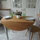 Walnut table with raised flaps, base on verdigris casters.