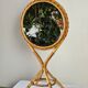 Vintage double-sided round mirror on a rattan stand.