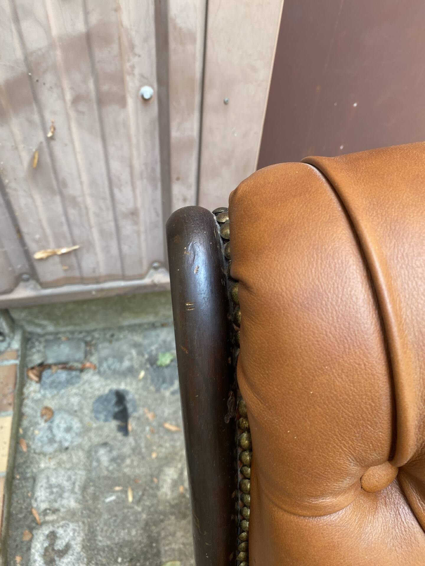 Chesterfield armchair in leather and carved solid wood