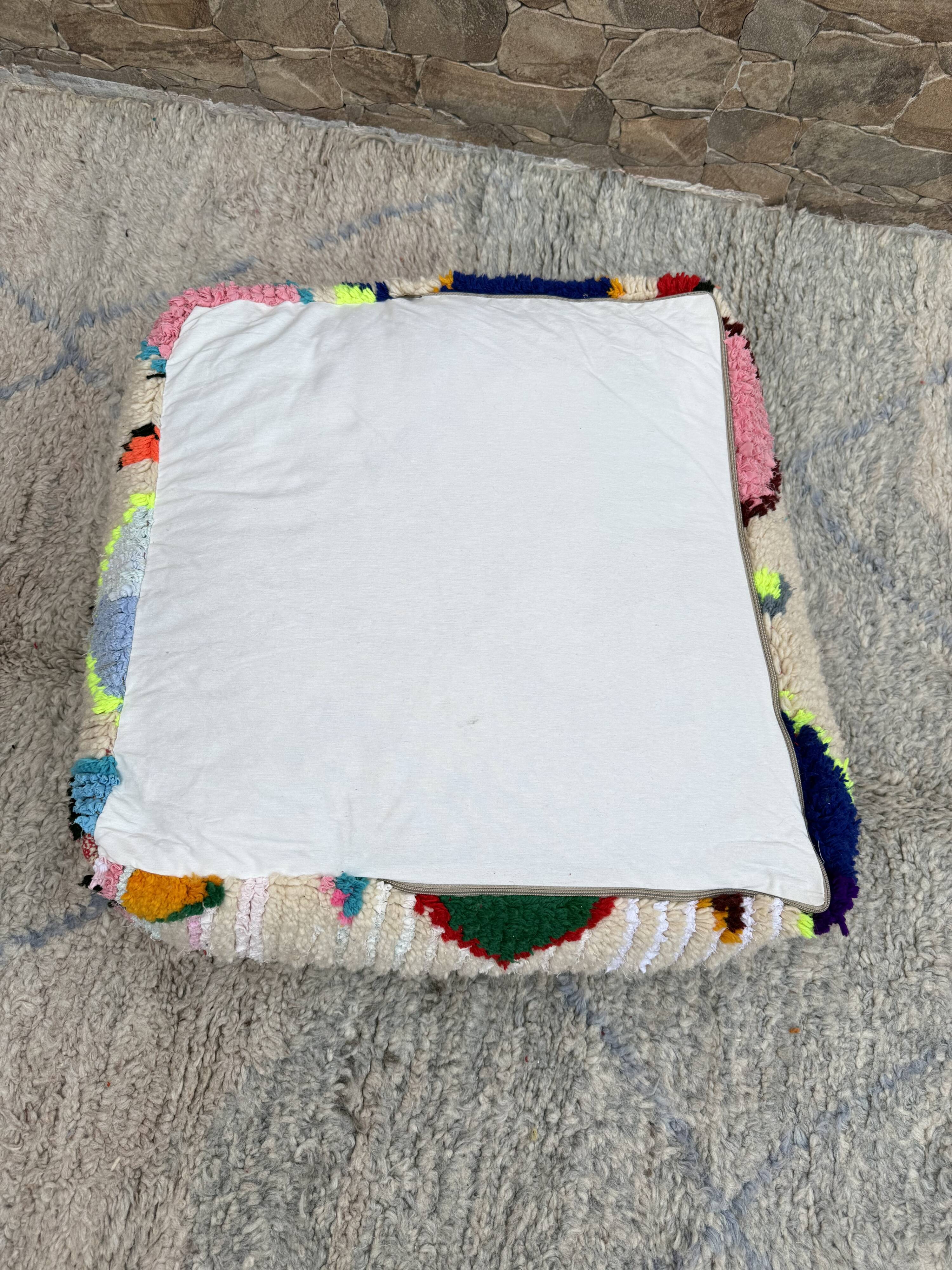 Berber floor pouf: Handwoven Moroccan wool cushion.