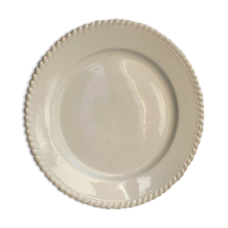 Old round serving dish in white earthenware with a saddled border