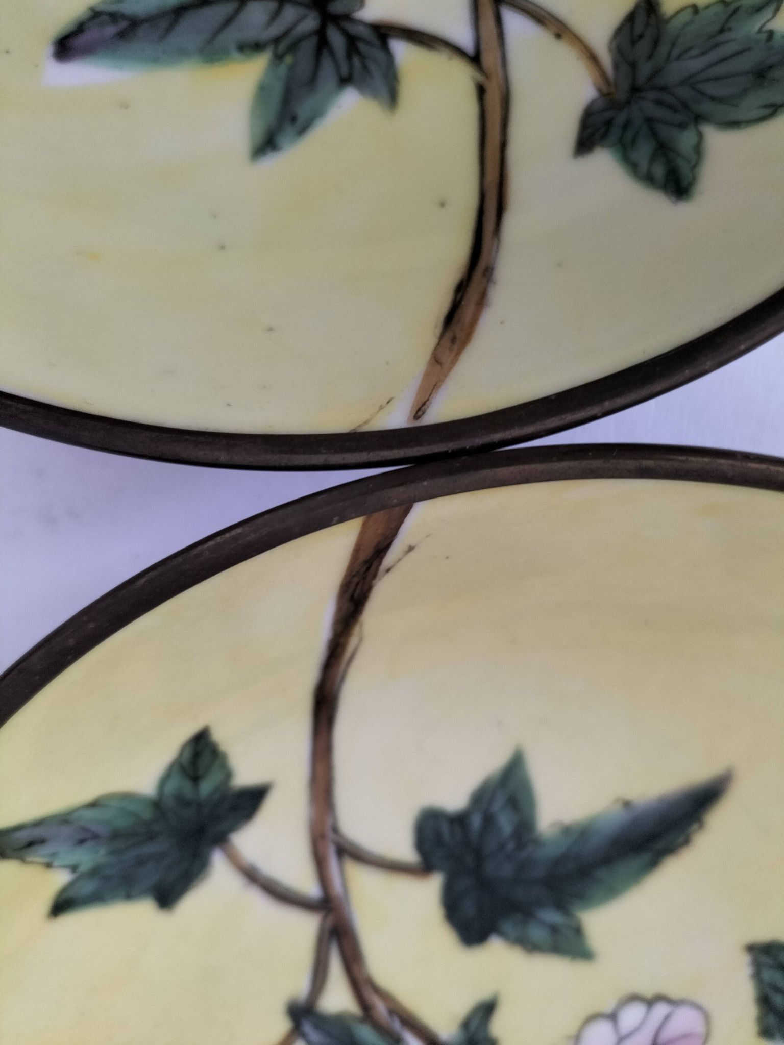 A pair of vintage Chinese decorative plates with floral designs on a yellow background.