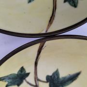 A pair of vintage Chinese decorative plates with floral designs on a yellow background.