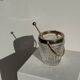 Small golden glass ice bucket with diamond point design and its scoop.