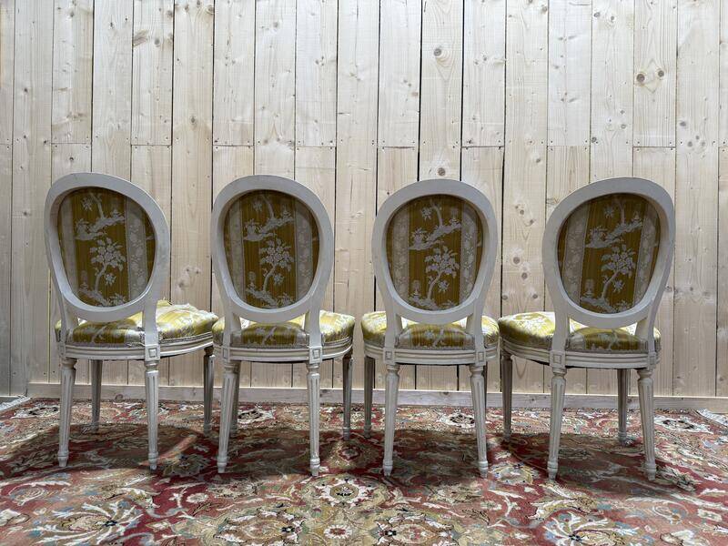 Suite de 4 chaises médaillons de style Louis XVI rechampi blanc cassé