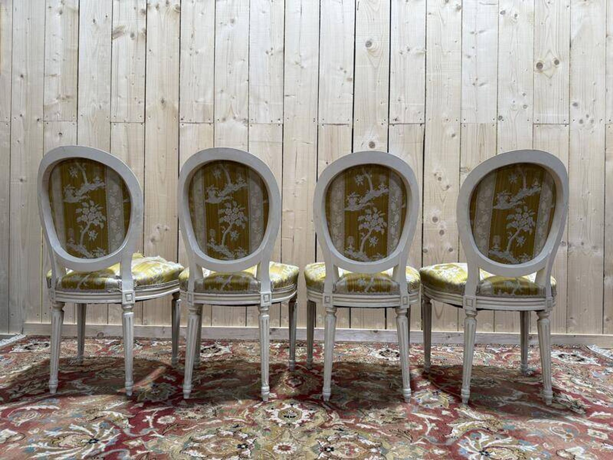 Suite de 4 chaises médaillons de style Louis XVI rechampi blanc cassé