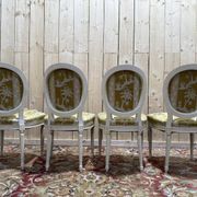 Suite de 4 chaises médaillons de style Louis XVI rechampi blanc cassé