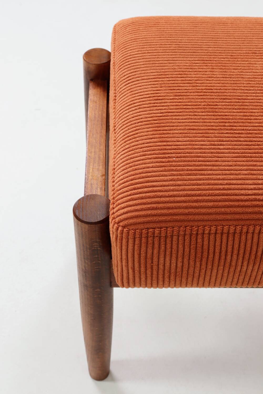 Vintage armchair and footrest in orange corduroy.