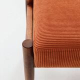 Vintage armchair and footrest in orange corduroy.