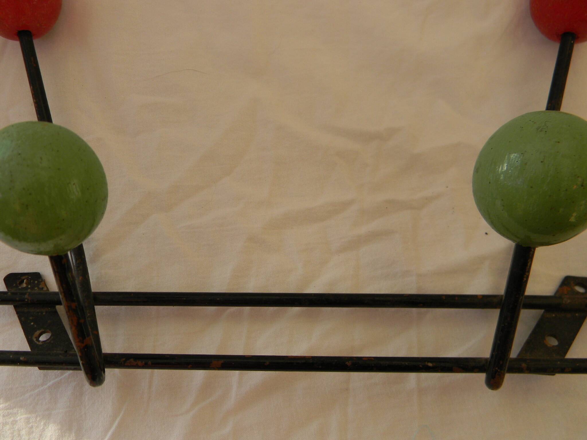 Small wrought iron coat rack with wooden balls.