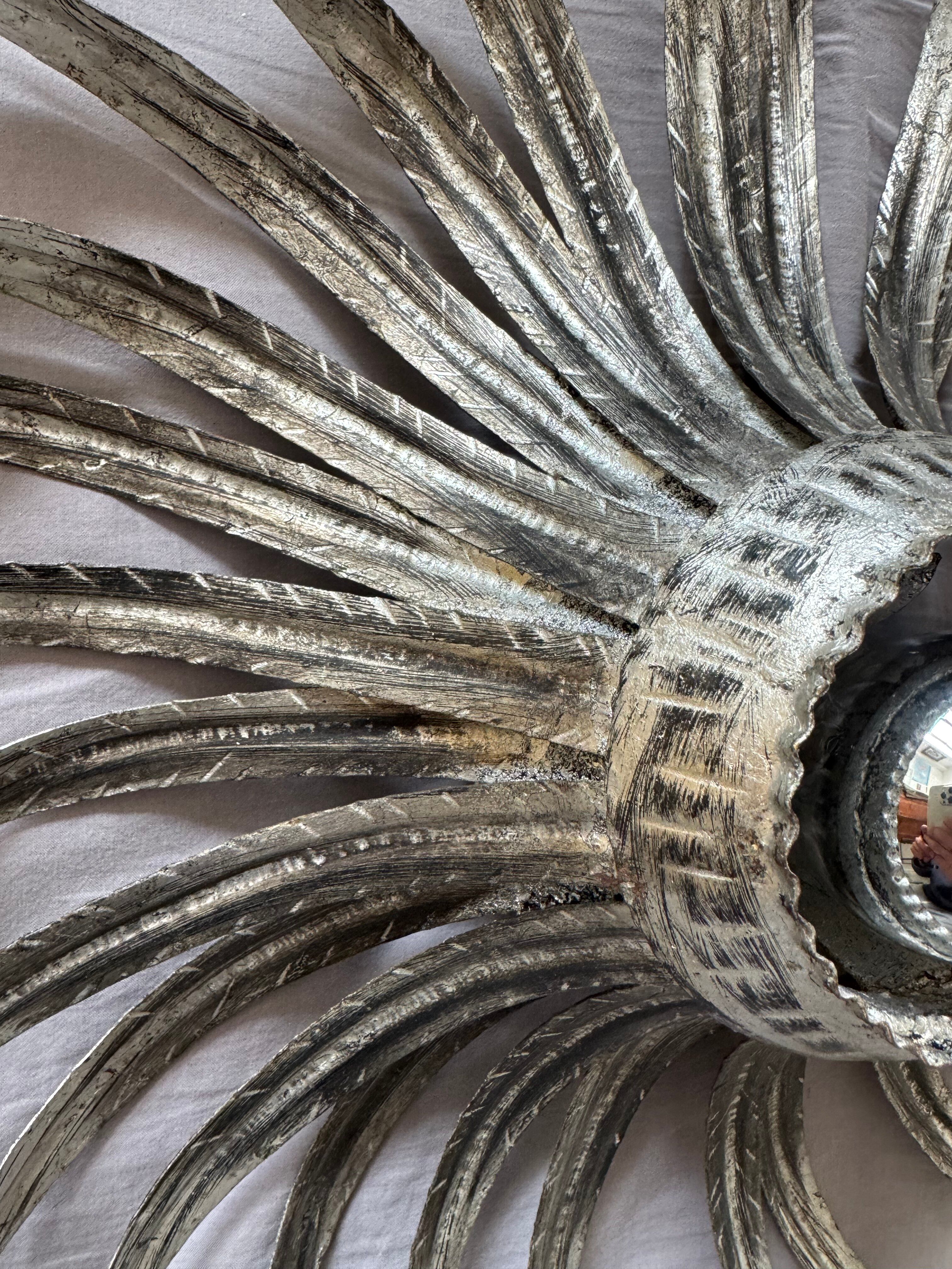 Silver wrought iron sunburst wall light from the 1960s.