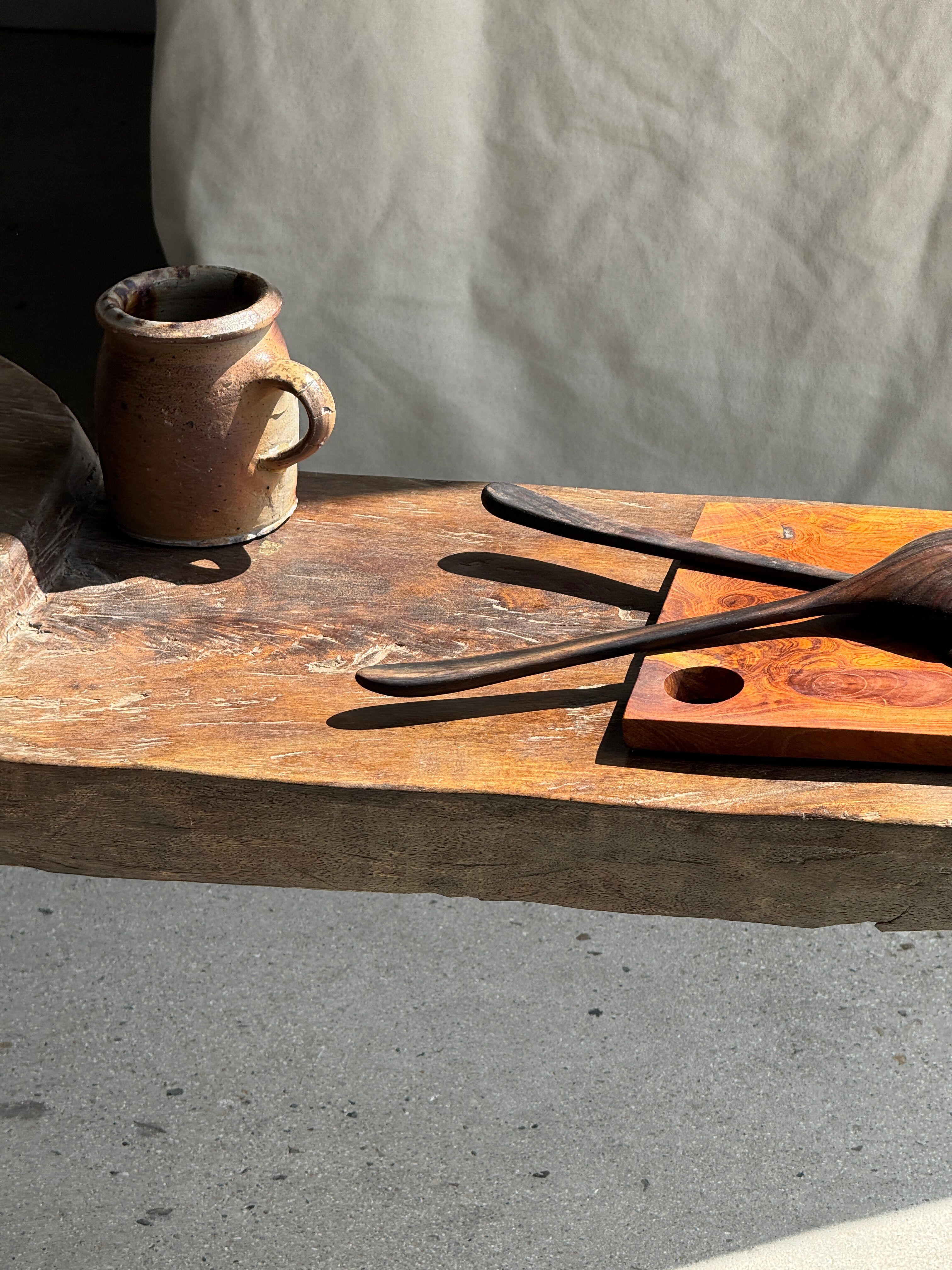 Small rectangular teak monoxyle cutting board with a circular handle.