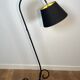 Design floor lamp in black lacquered metal and brass.