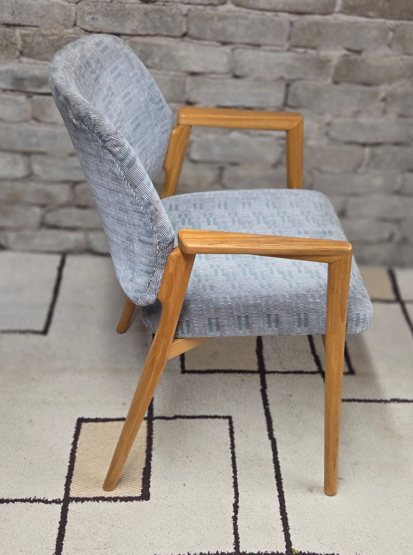 Vintage armchair from the 60s/70s in wood and grey fabric – with armrests.