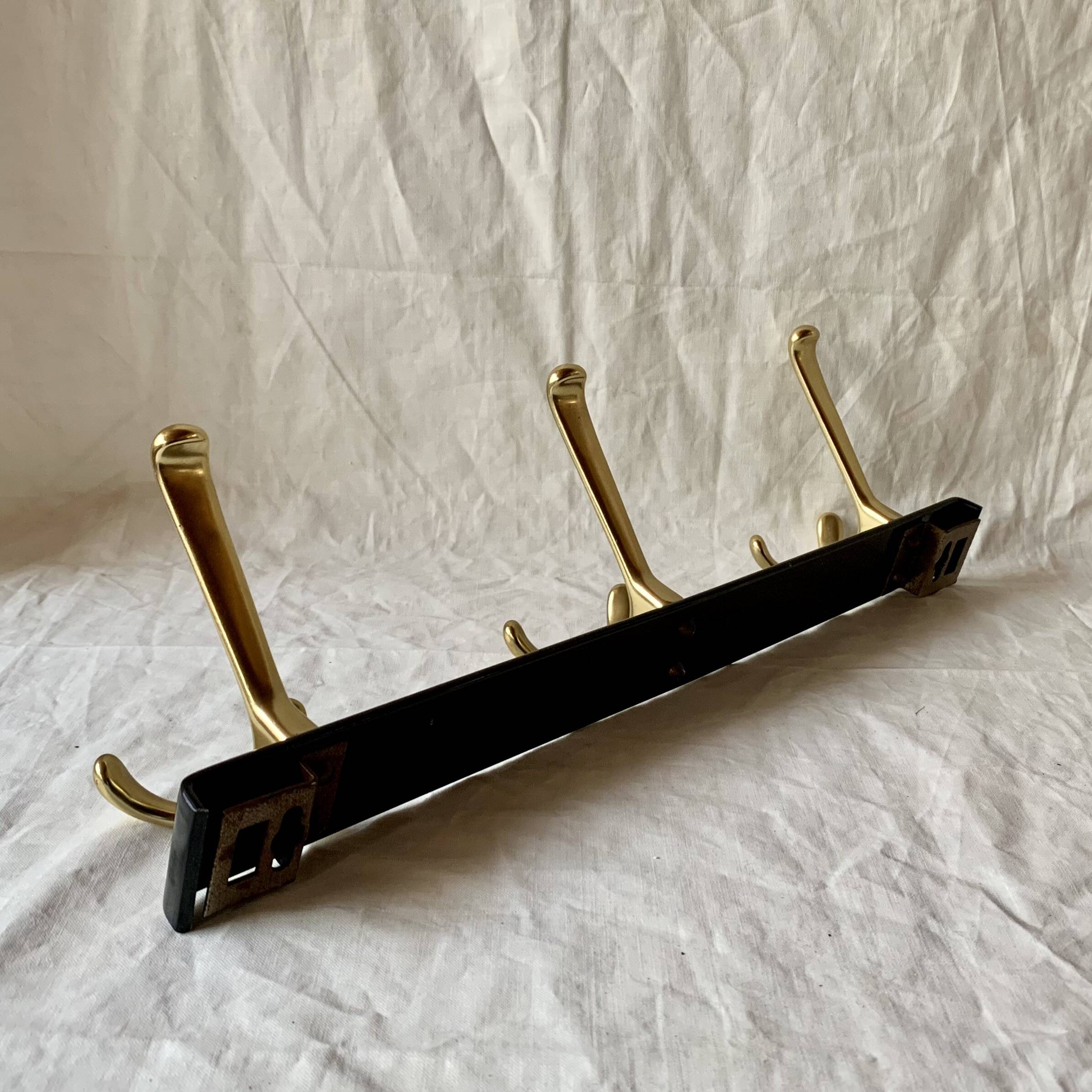 Vintage coat rack in lacquered metal with three golden aluminum hooks