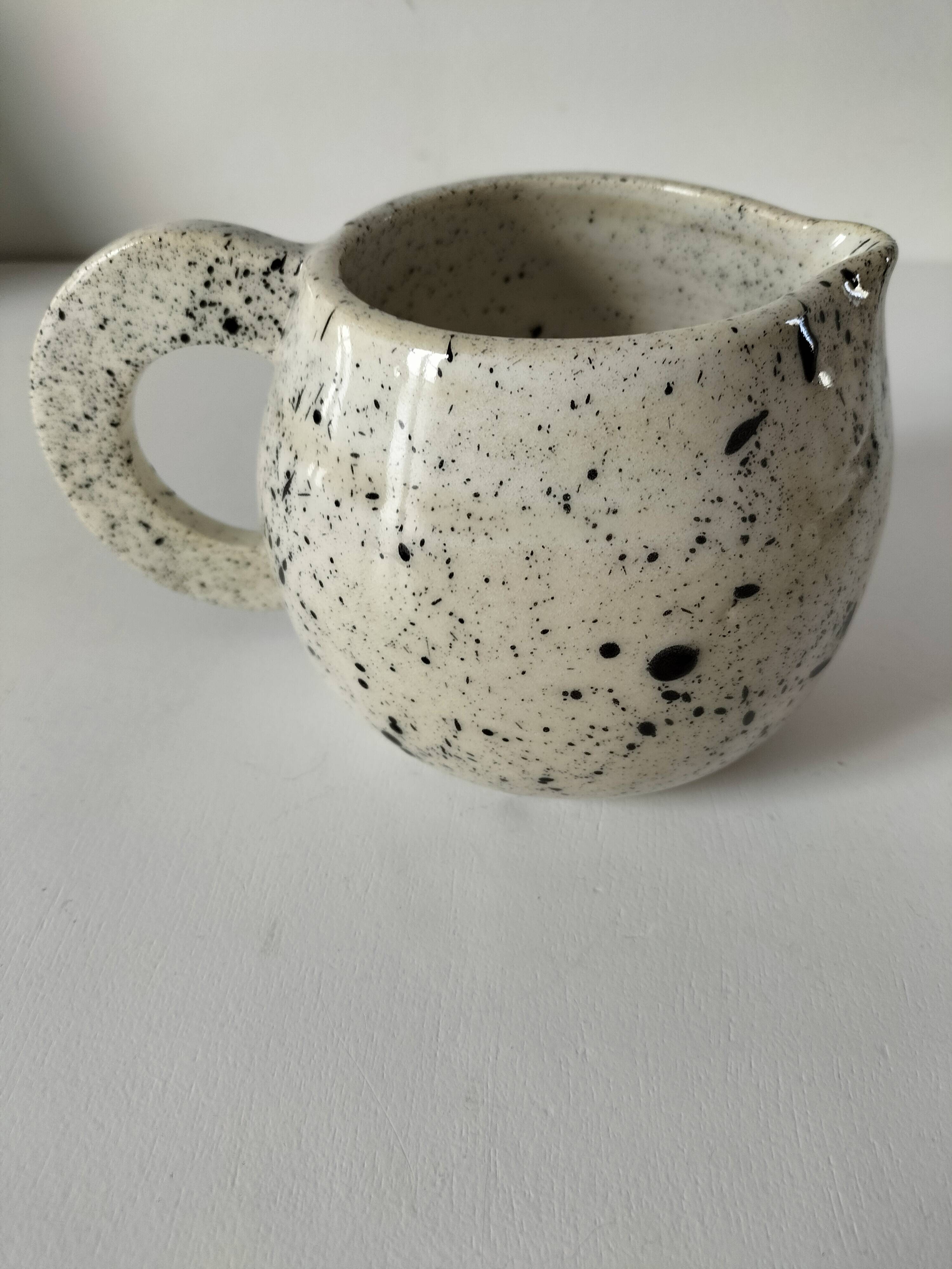 Small speckled ceramic jug in a vintage workshop style.
