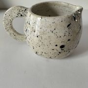 Small speckled ceramic jug in a vintage workshop style.