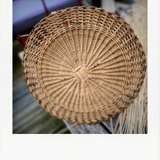 Round mirror in dark rattan