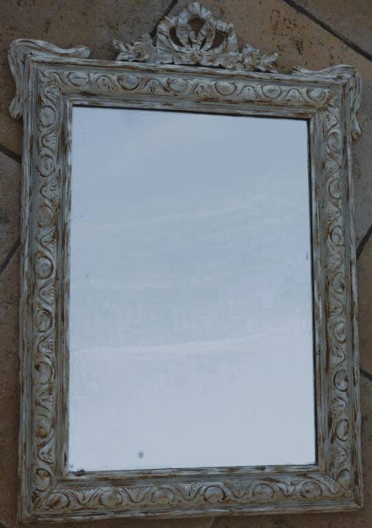 Chic and stylish antique mirror with carved wooden frame in whitewashed
