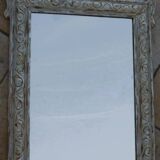 Chic and stylish antique mirror with carved wooden frame in whitewashed