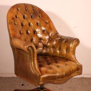 Office chair known as a presidential chair in mahogany and cognac leather.