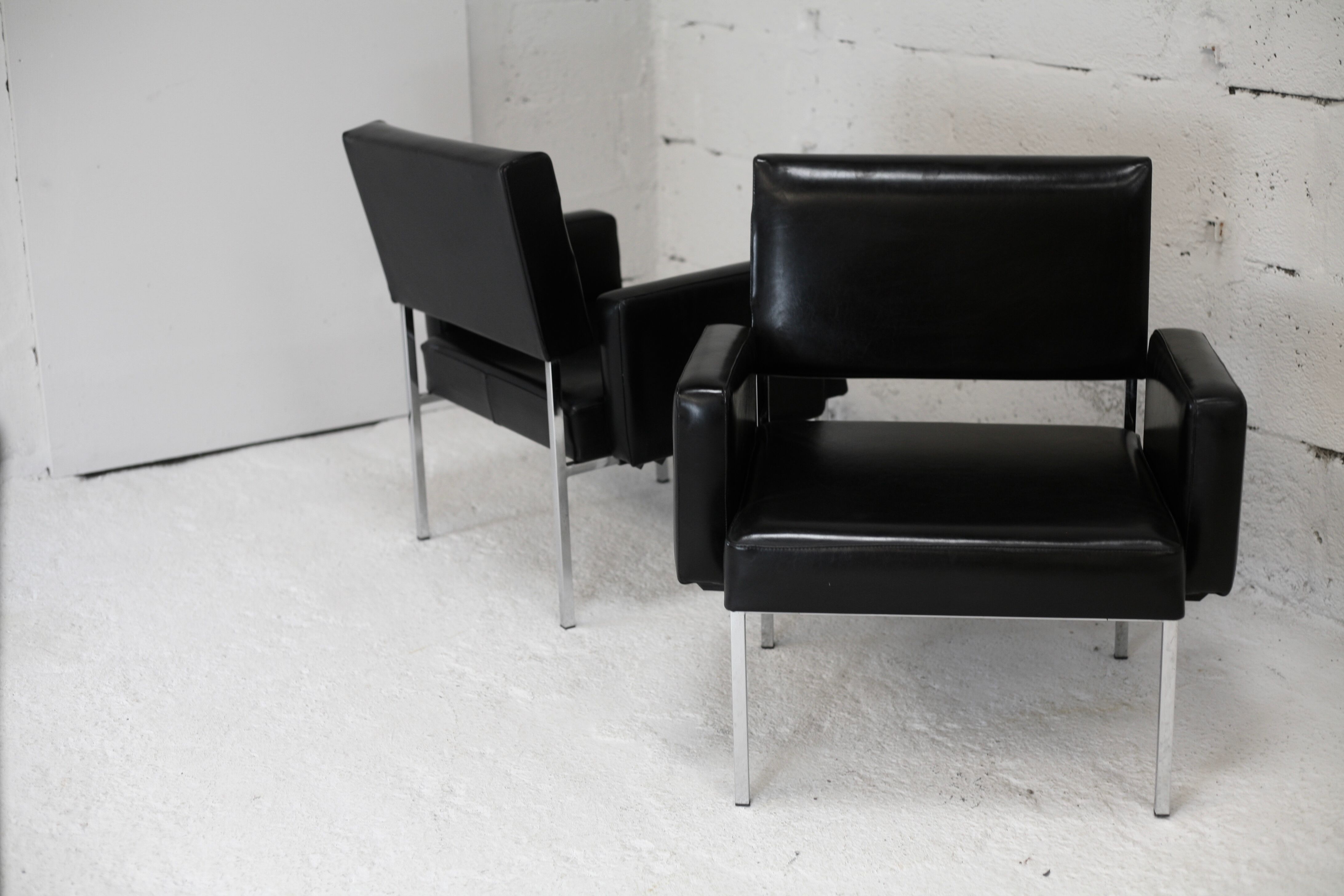 Pair of stainless steel, black leather-like armchairs, France, circa 1970