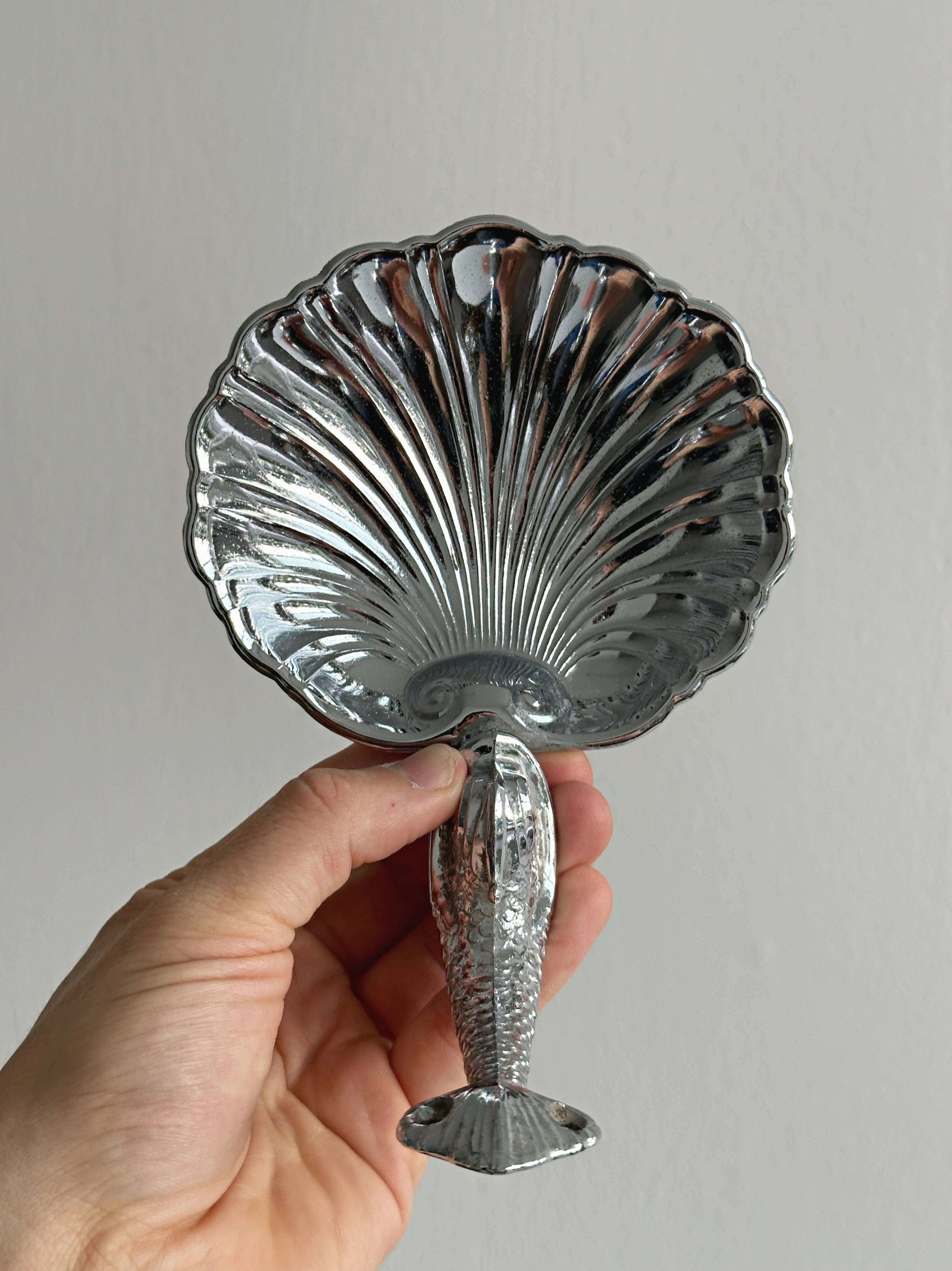 Soap dish, shell-shaped lightweight metal catchall.