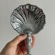Soap dish, shell-shaped lightweight metal catchall.