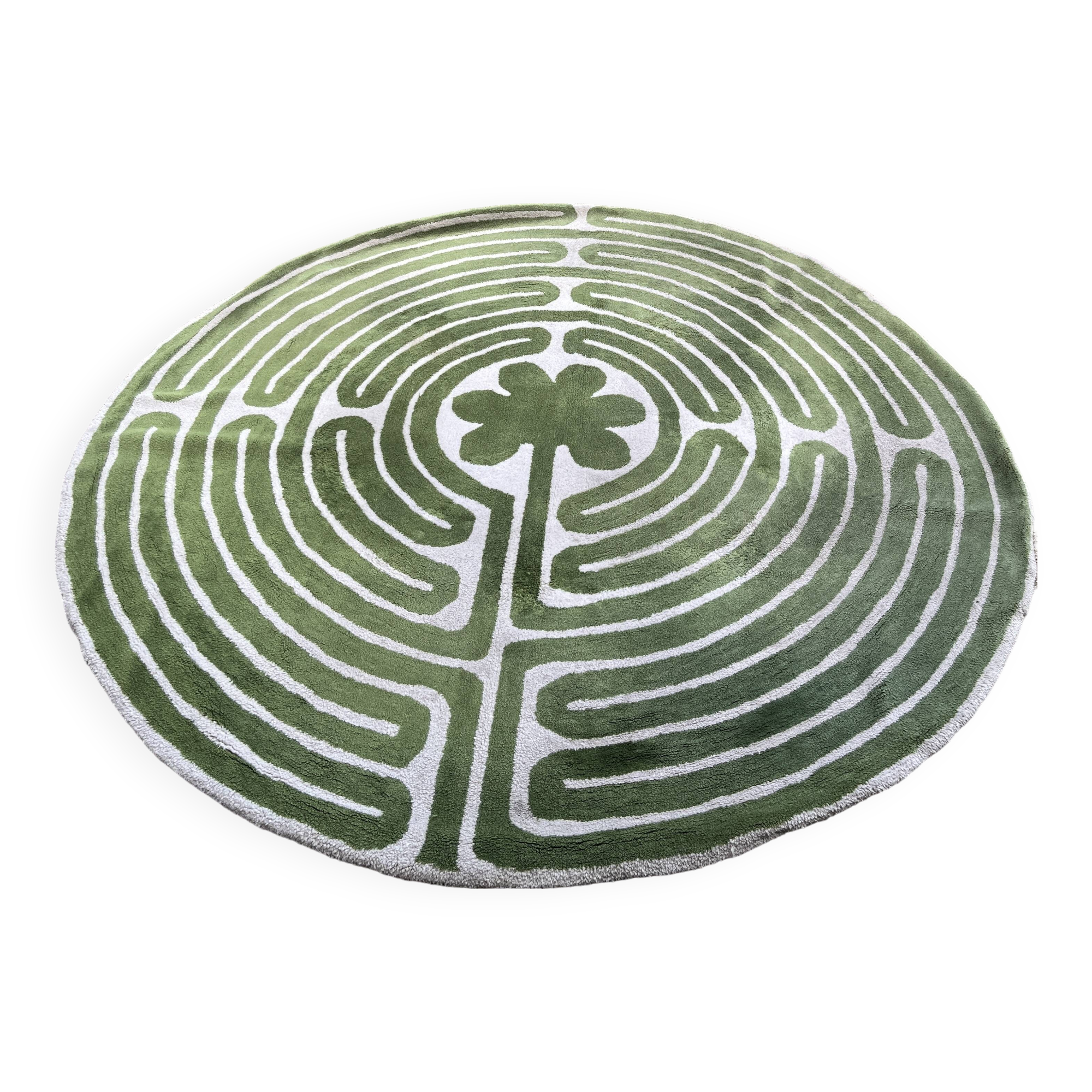 Circular rug with green decor on a cream background from the Labyrinth.
