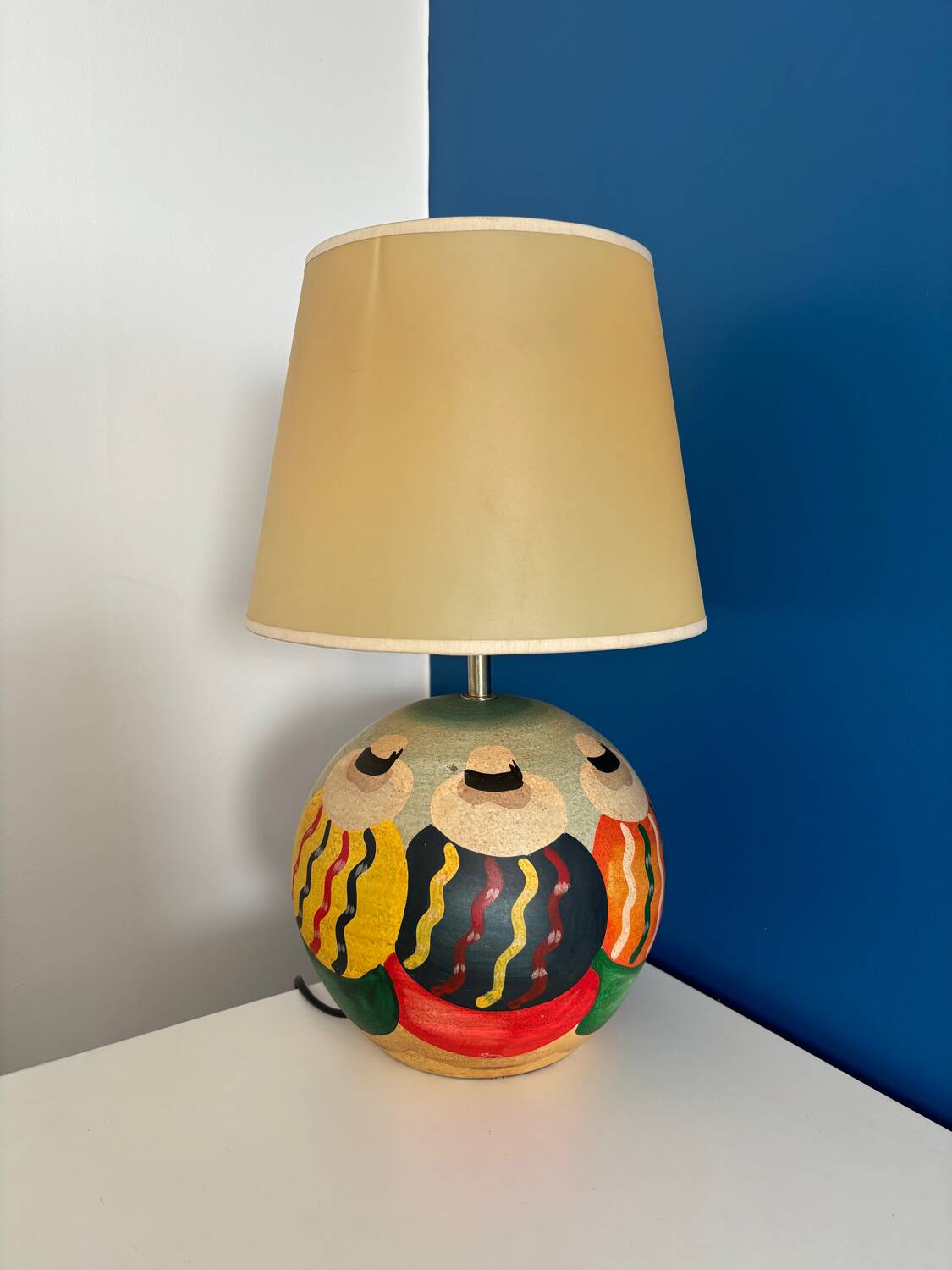 Ceramic table lamp representing women in hats on the sand.