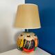 Ceramic table lamp representing women in hats on the sand.
