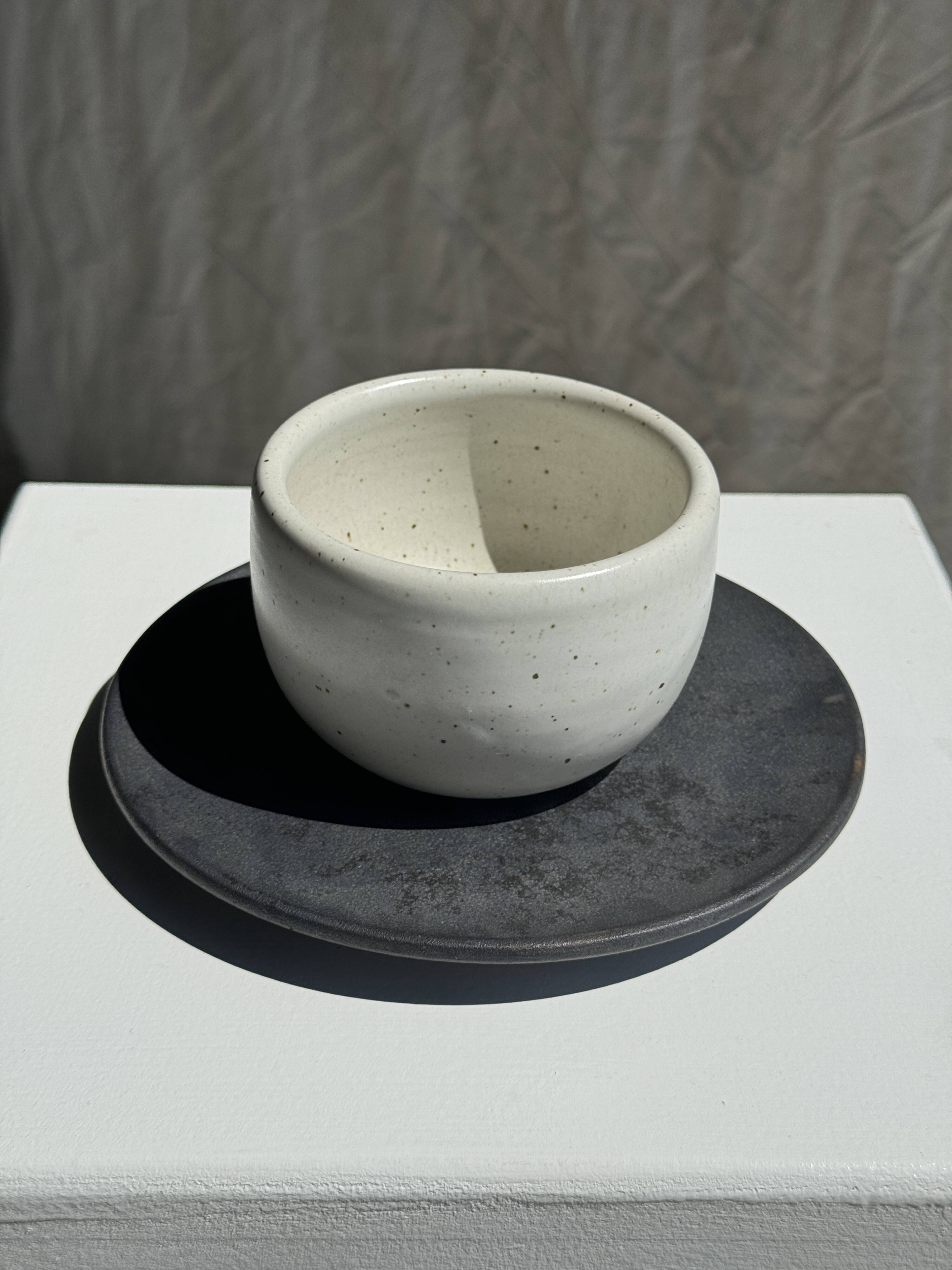 White Indonesian ceramic cup and gray saucer
