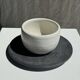 White Indonesian ceramic cup and gray saucer