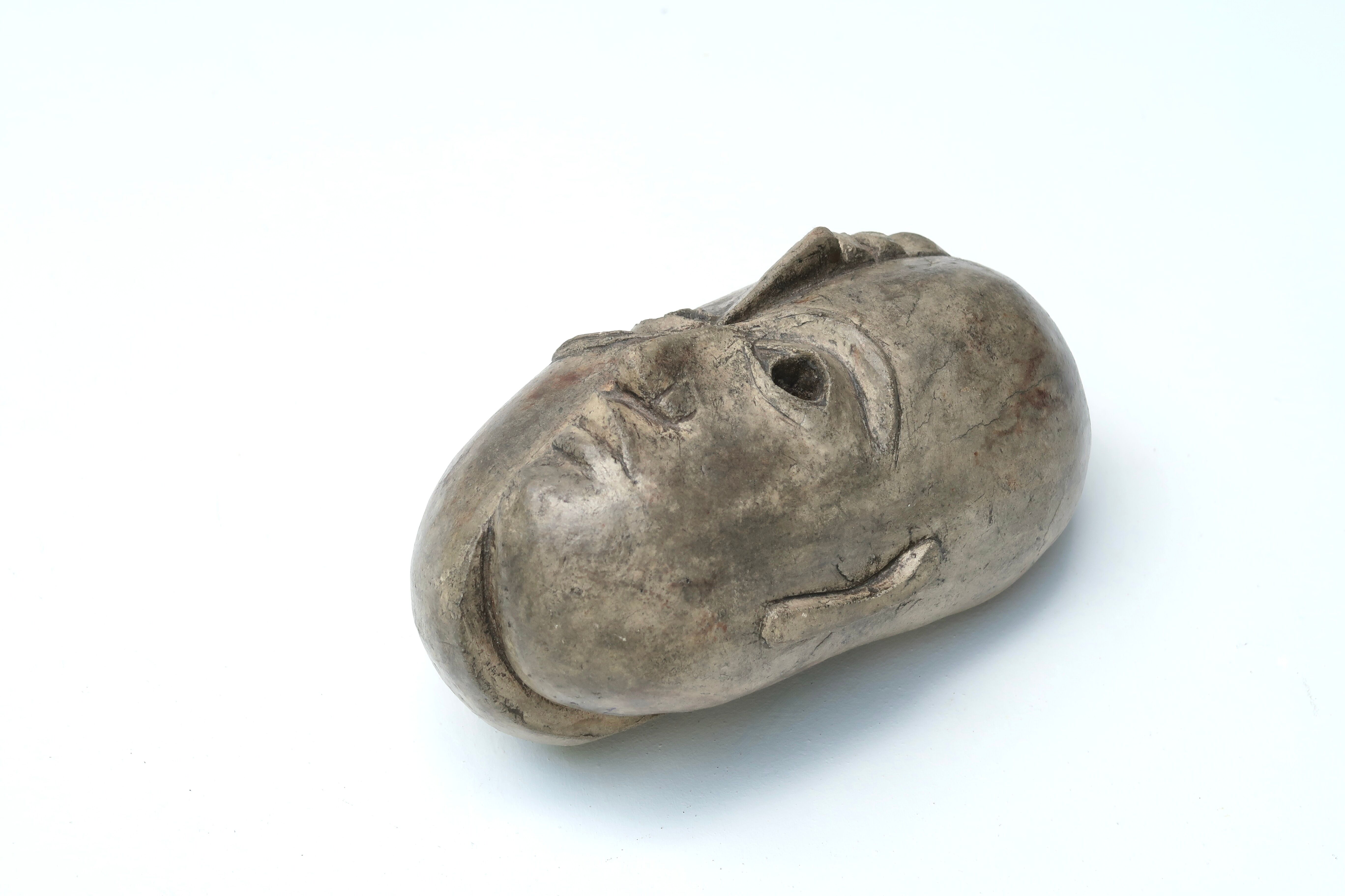 Patinated plaster sculpture paper press: Inverted faces