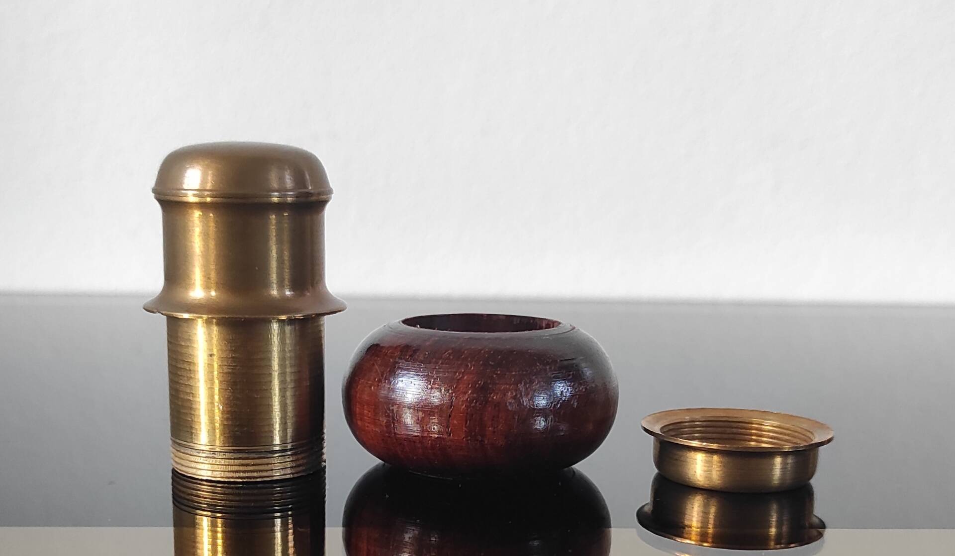 Vintage salt and pepper shaker duo in brass and turned wood.
