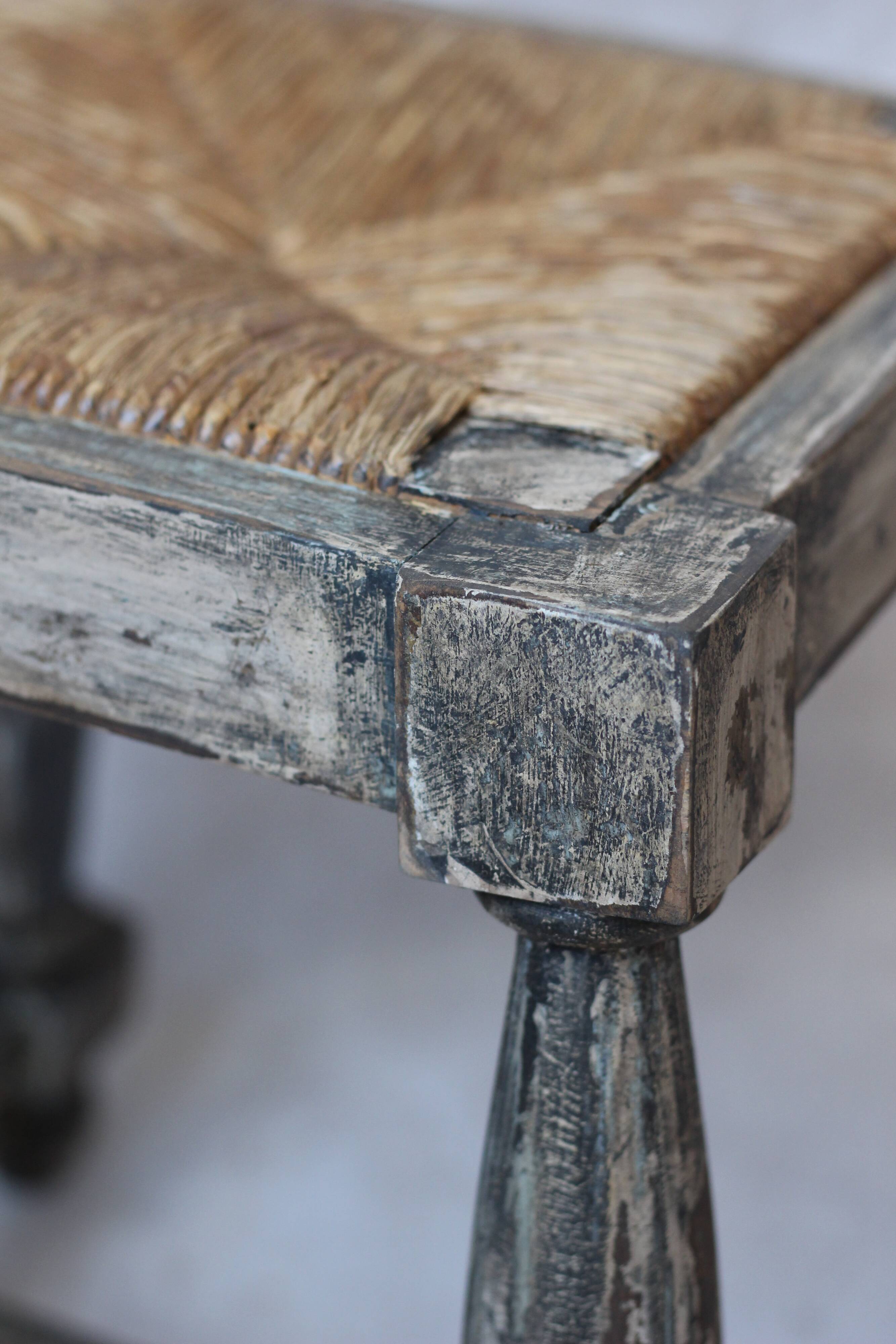 Patinated wooden stool with straw seat