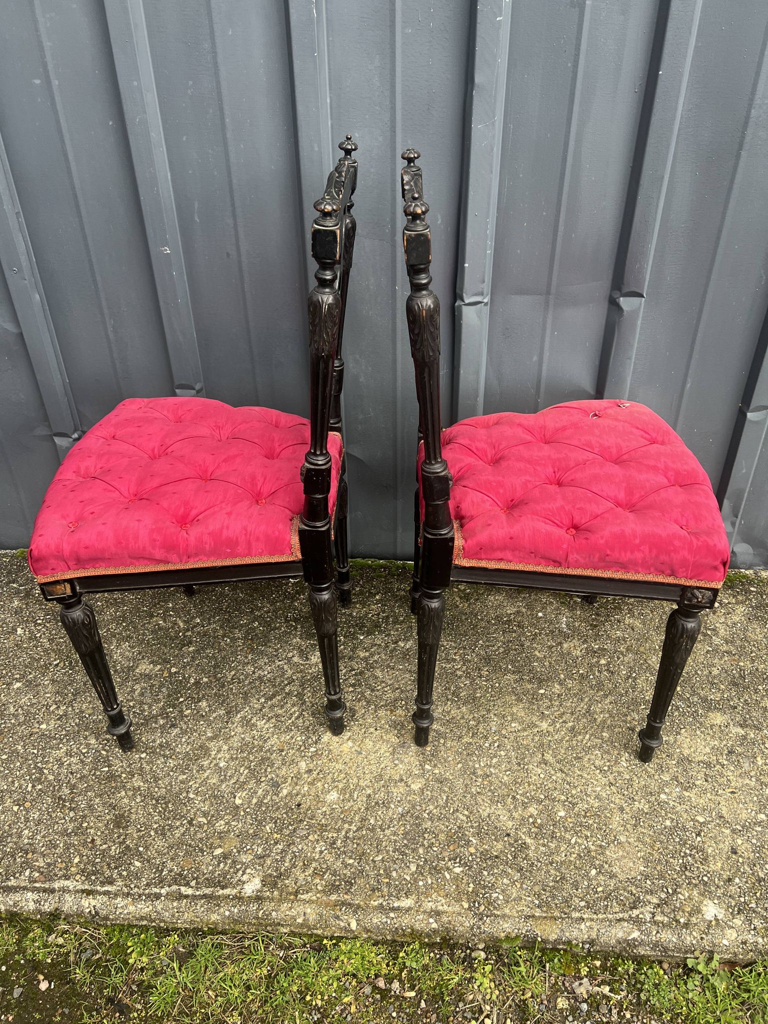 Pair of black lacquered chairs with purple tufted upholstery.