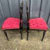 Pair of black lacquered chairs with purple tufted upholstery.