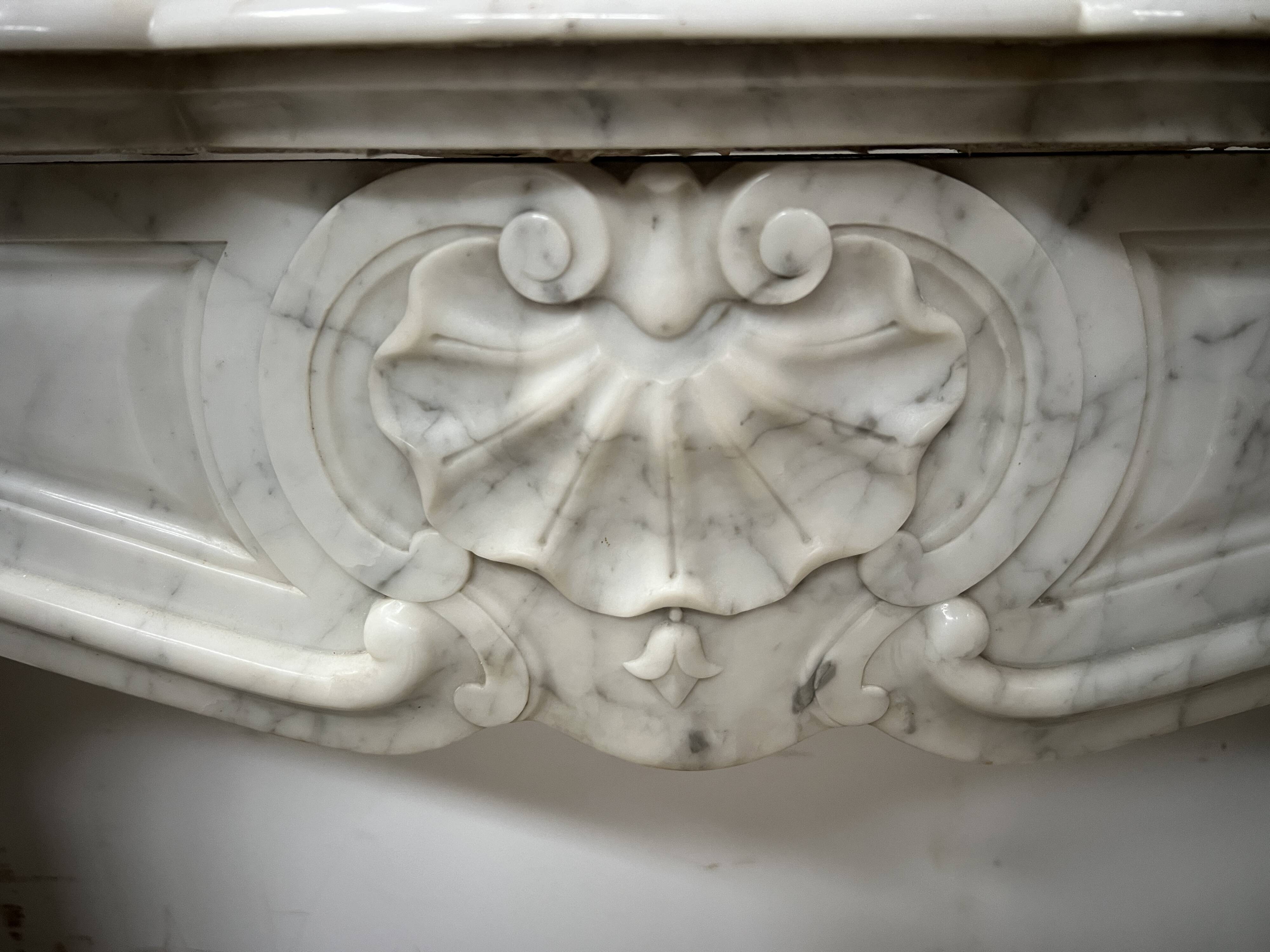 Louis XV style fireplace in veined white marble, 20th century.