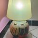 Ceramic table lamp representing women in hats on the sand.