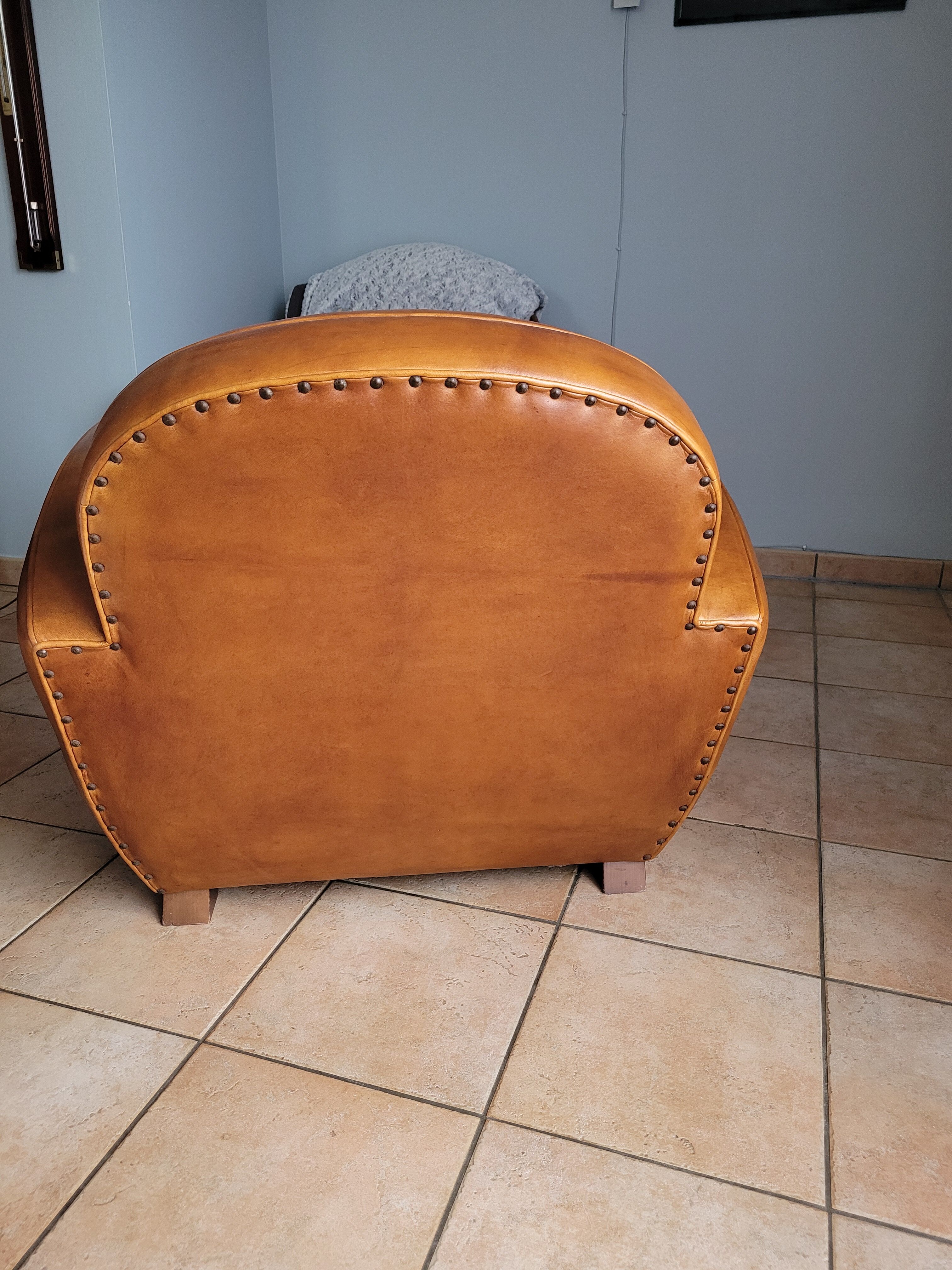 Leather club armchair and its pouf