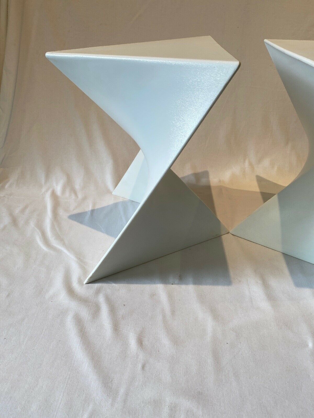 Pair of unmarked triangular white design stools