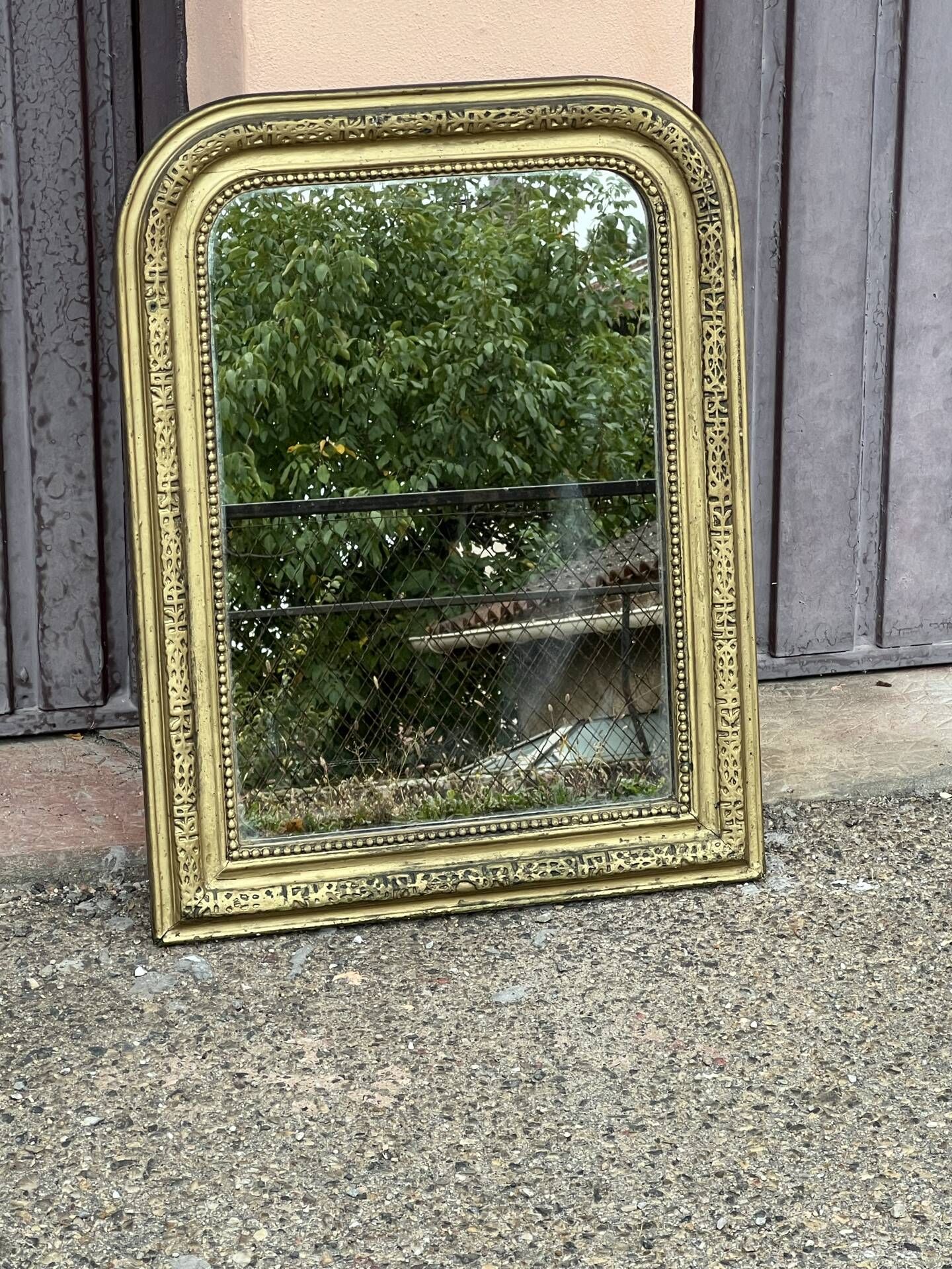 Louis Philippe mirror in gilded wood with an openwork frieze.
