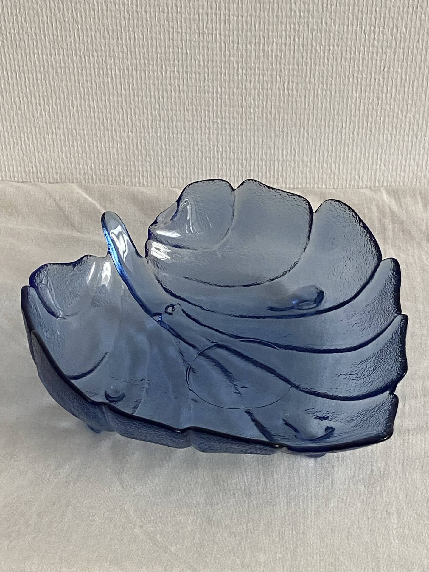 Large leaf-shaped fruit bowl, made of moulded blue glass.
