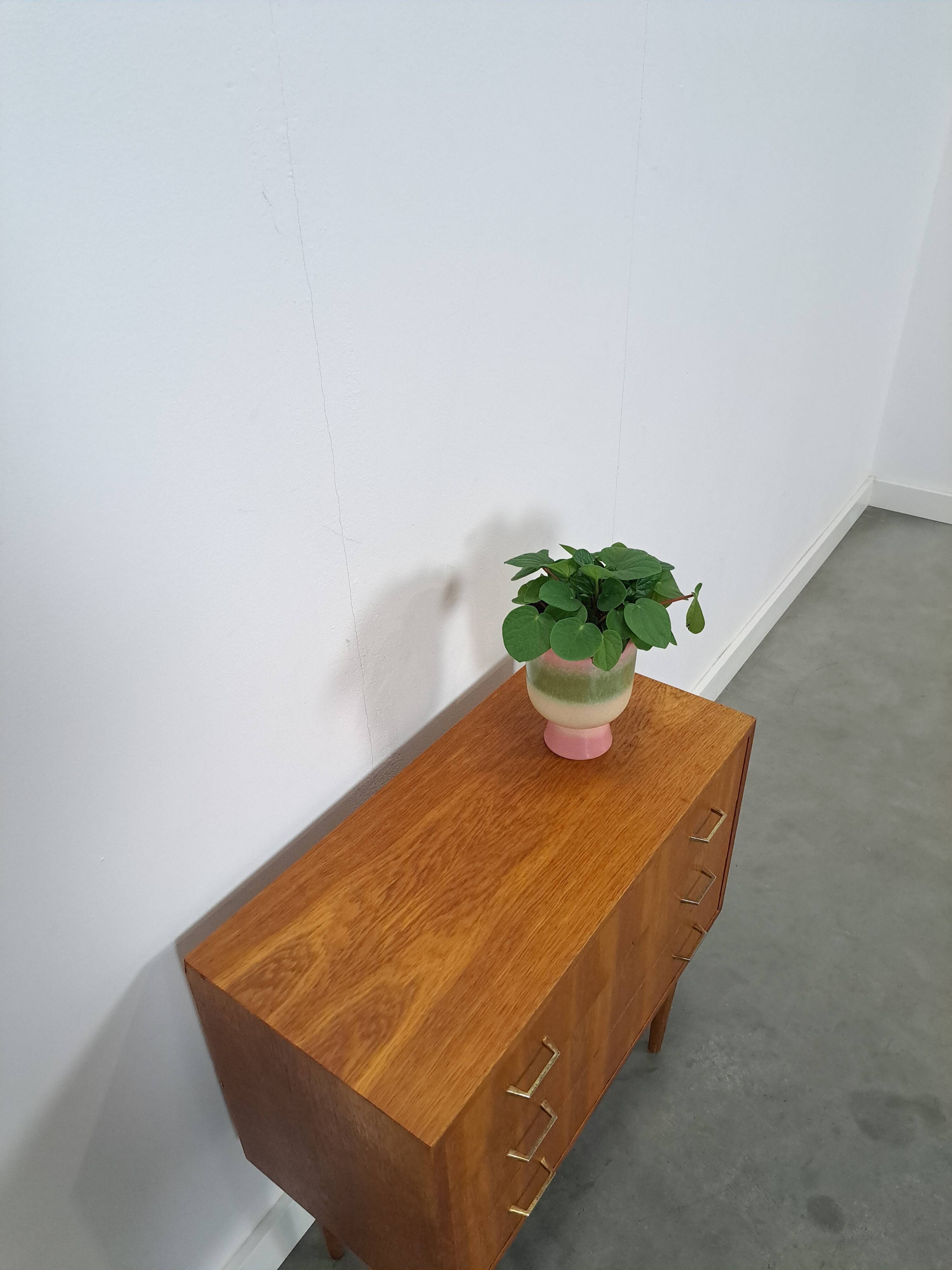 Commode danoise avec de hauts pieds et des poignées dorées.