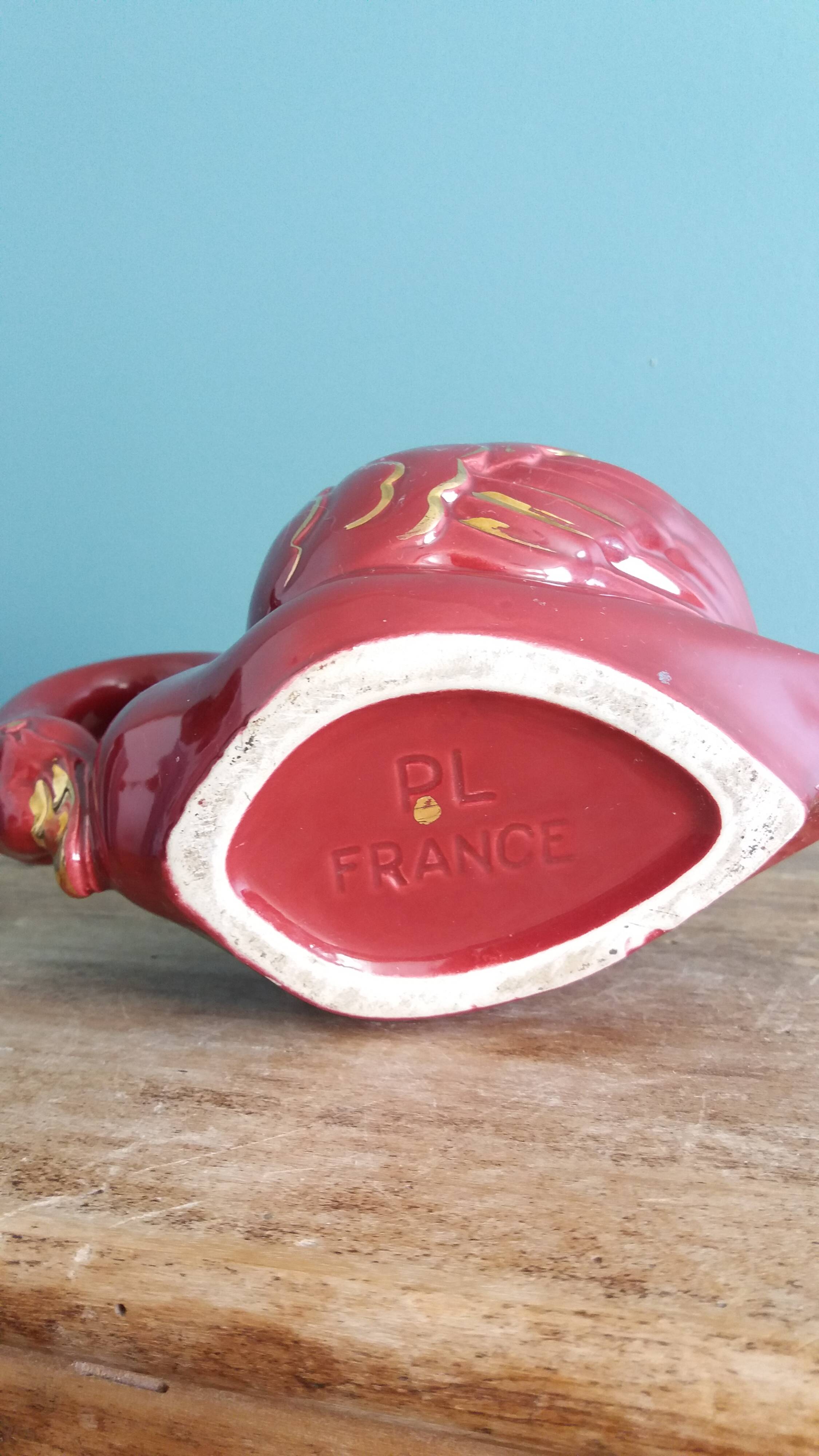 Poet Laval swan hides zoomorphic pot in burgundy ceramic.