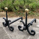 Massive wrought iron chenets from the 19th century topped with brass balls.