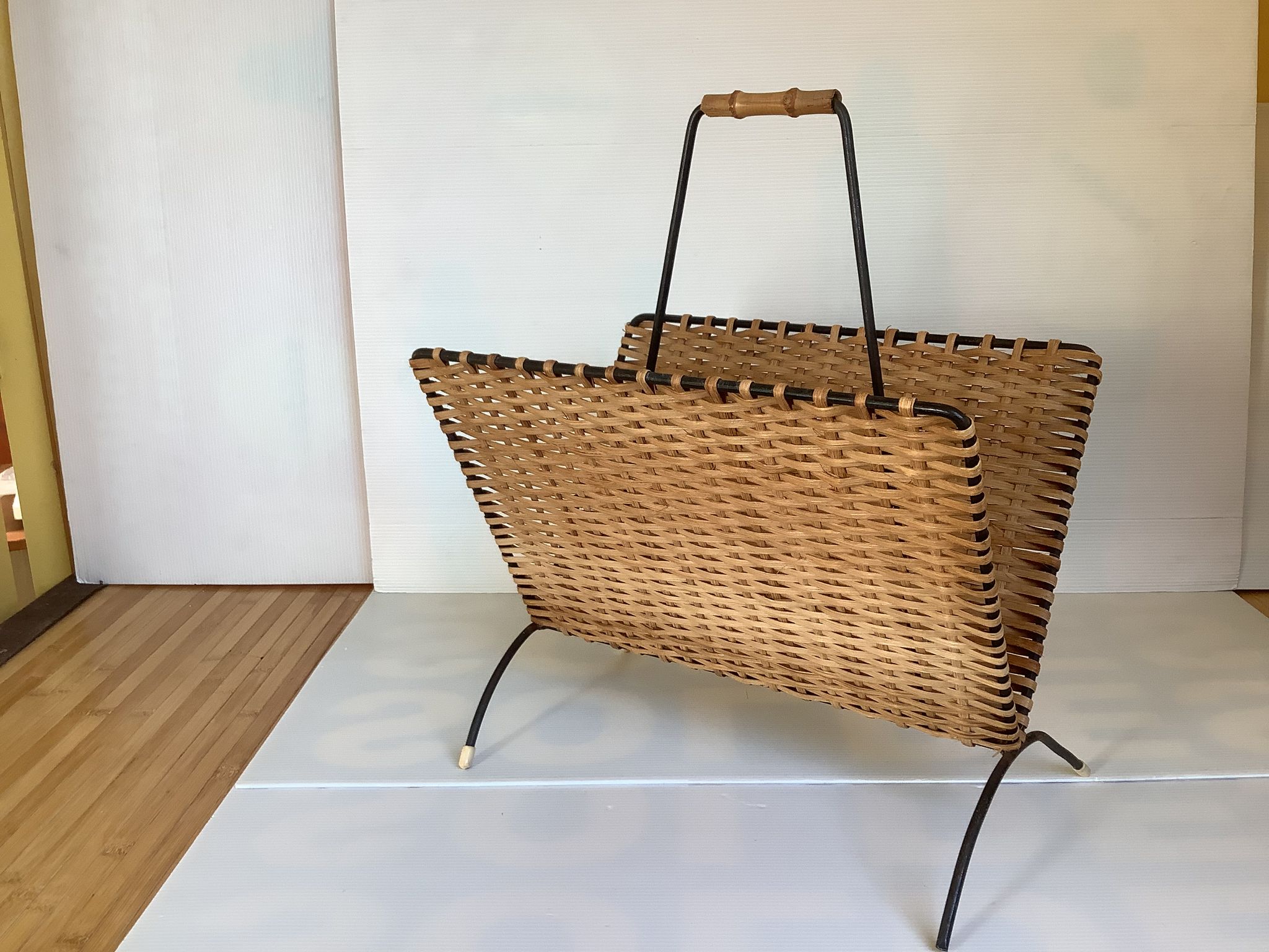 Old magazine rack in straw and black metal