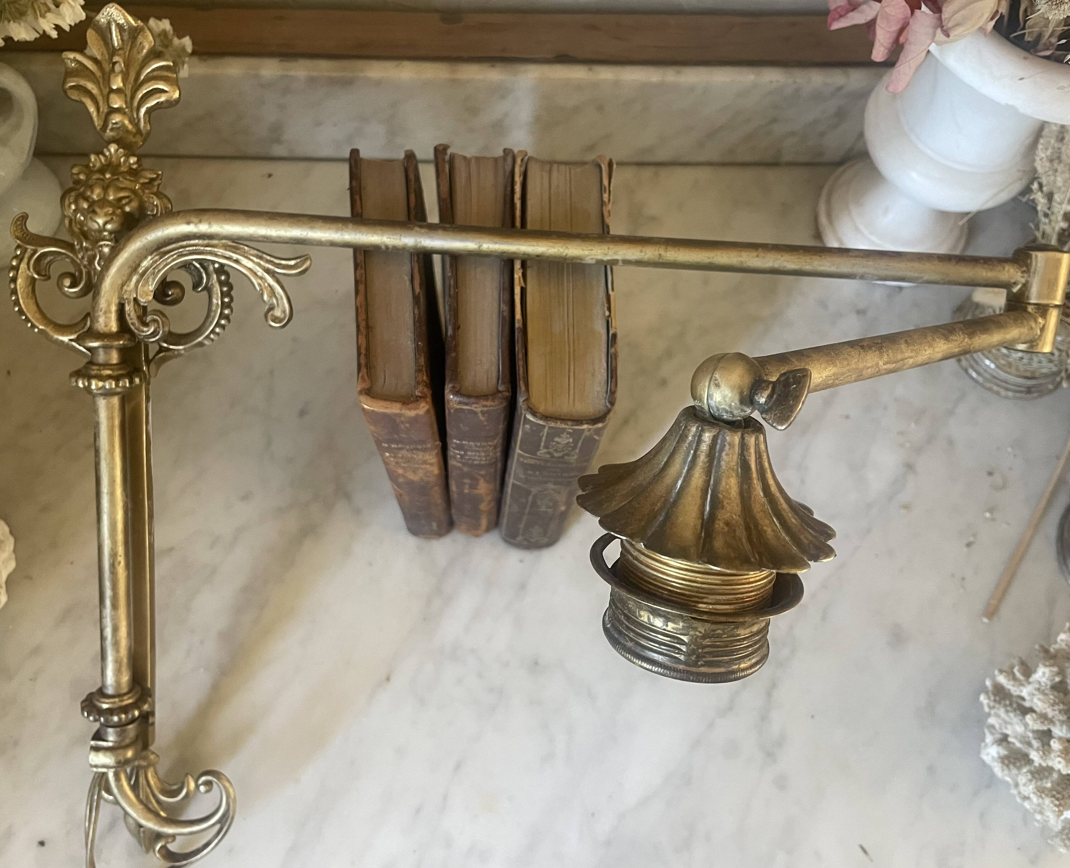 Adjustable wall light in brass and gold metal.