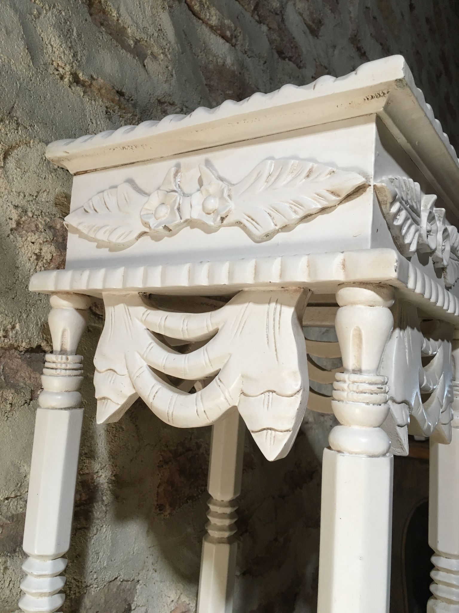 Carved wooden stool with a white patina.